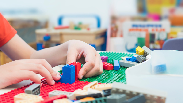 child playing with lego on a table