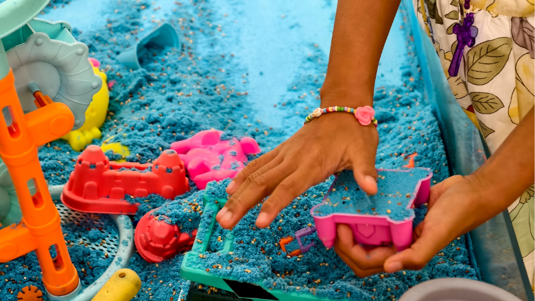 child playing with kinetic sand on a table